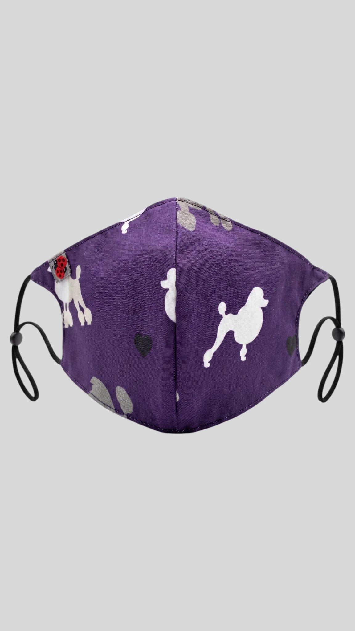Ladybird Line 29 purple pet grooming face mask with white poodle silhouette, gray paw print, and black heart pattern, featuring adjustable black elastic ear loops shown against a solid gray background.