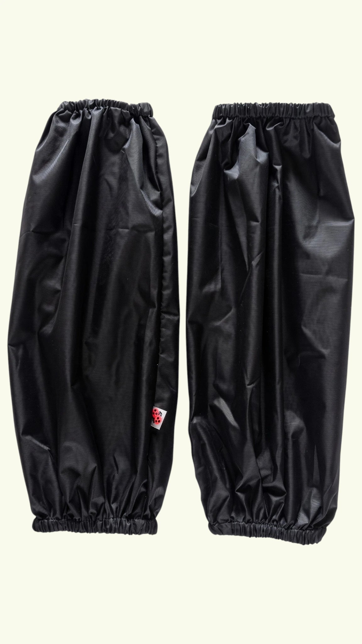 Pair of Ladybird Line 606 waterproof black dog bathing and pet grooming arm sleeves with elastic wrist and arm bands, shown flat against a light cream background.