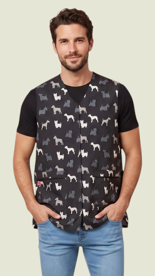 Front view of a man with short brown hair and a beard modeling the Ladybird Line 815 Men's Terrier Print Waterproof & Bleach Resistant Grooming Vest, featuring a black v-neck grooming vest with a white terrier print pattern and front zip pockets, worn over a black t-shirt and blue jeans against a light beige background.